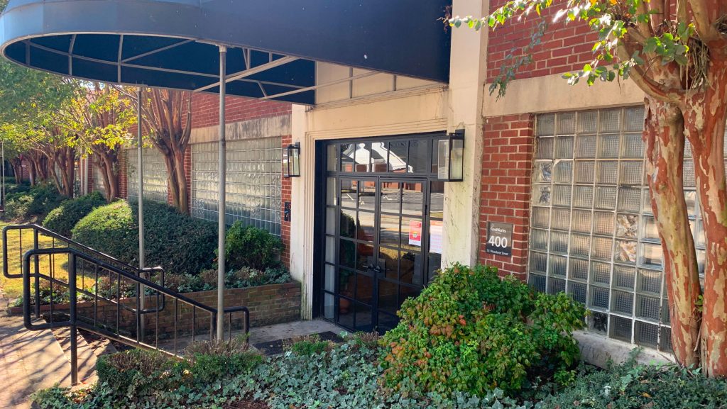 The entrance to a brick building with a get started awning.