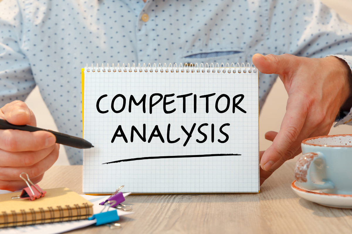 A man conducting SEO competitor analysis and showing it on a piece of paper.