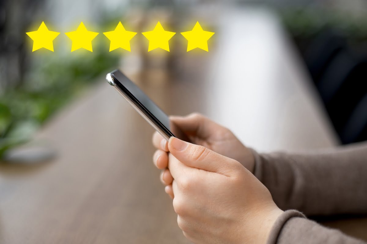 A person holding a phone, trying to get more reviews on Google.