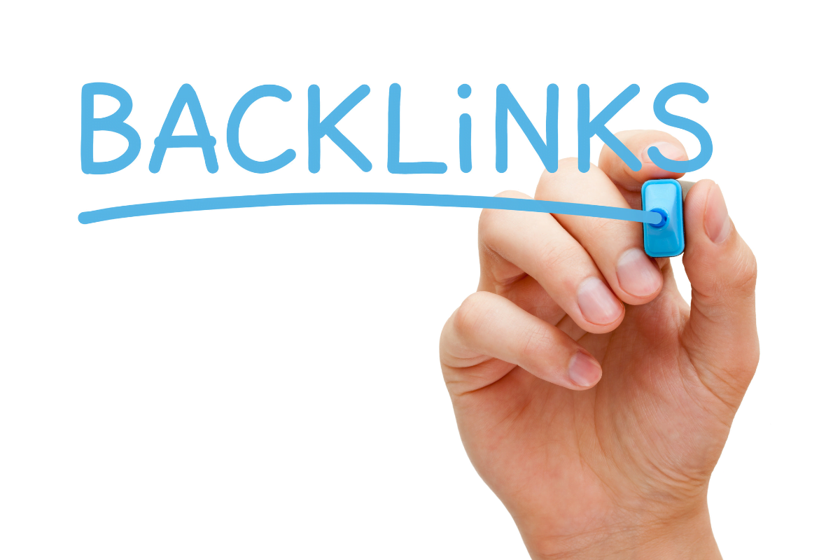 A hand skillfully writing the word backlinks on a piece of paper.