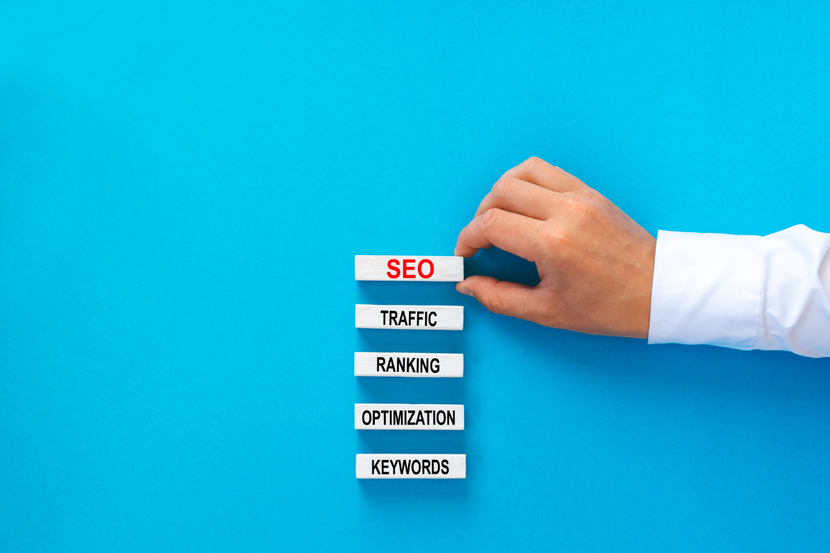 A man is holding an SEO sign on a blue background.