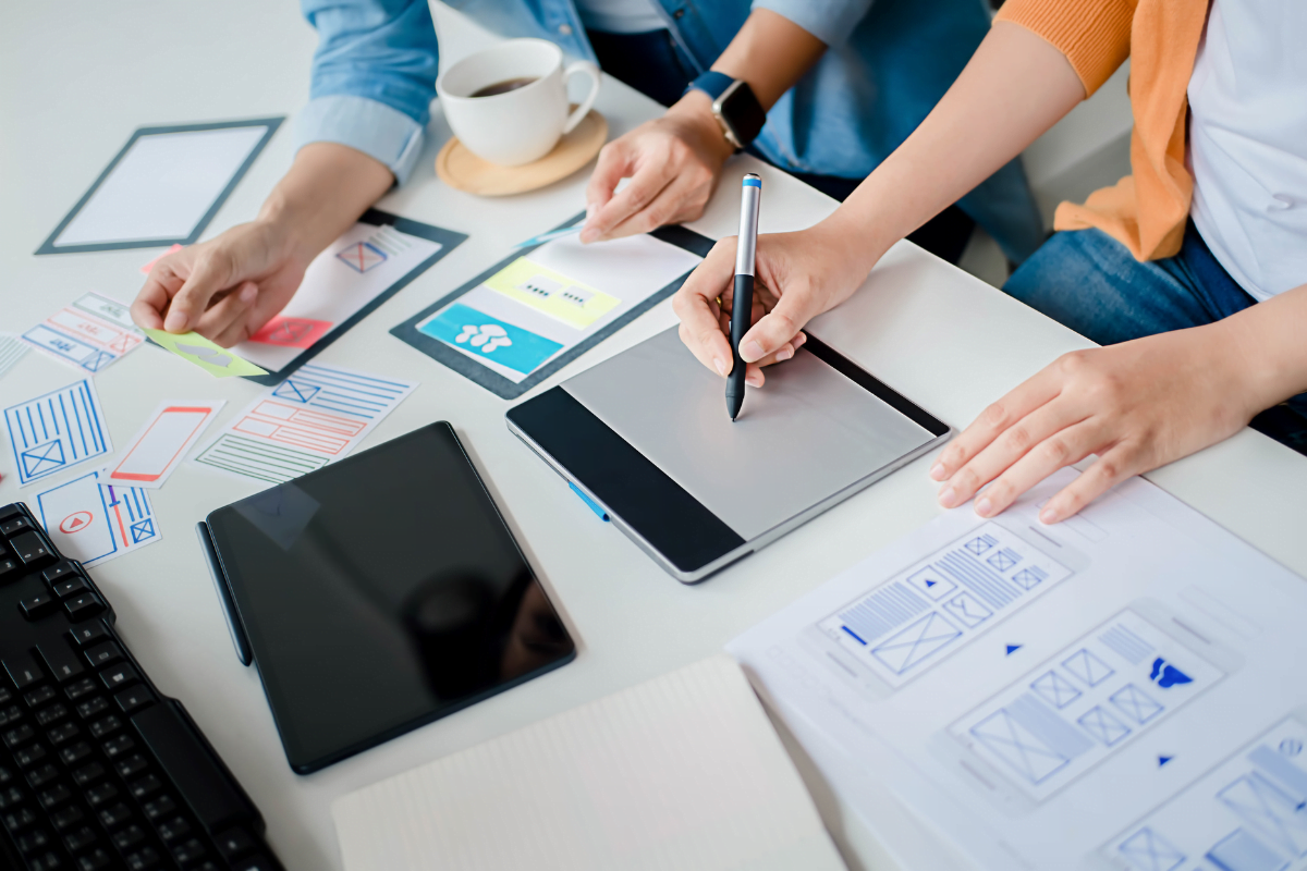 A group of people showing the benefits of simplicity in web design working at a desk.