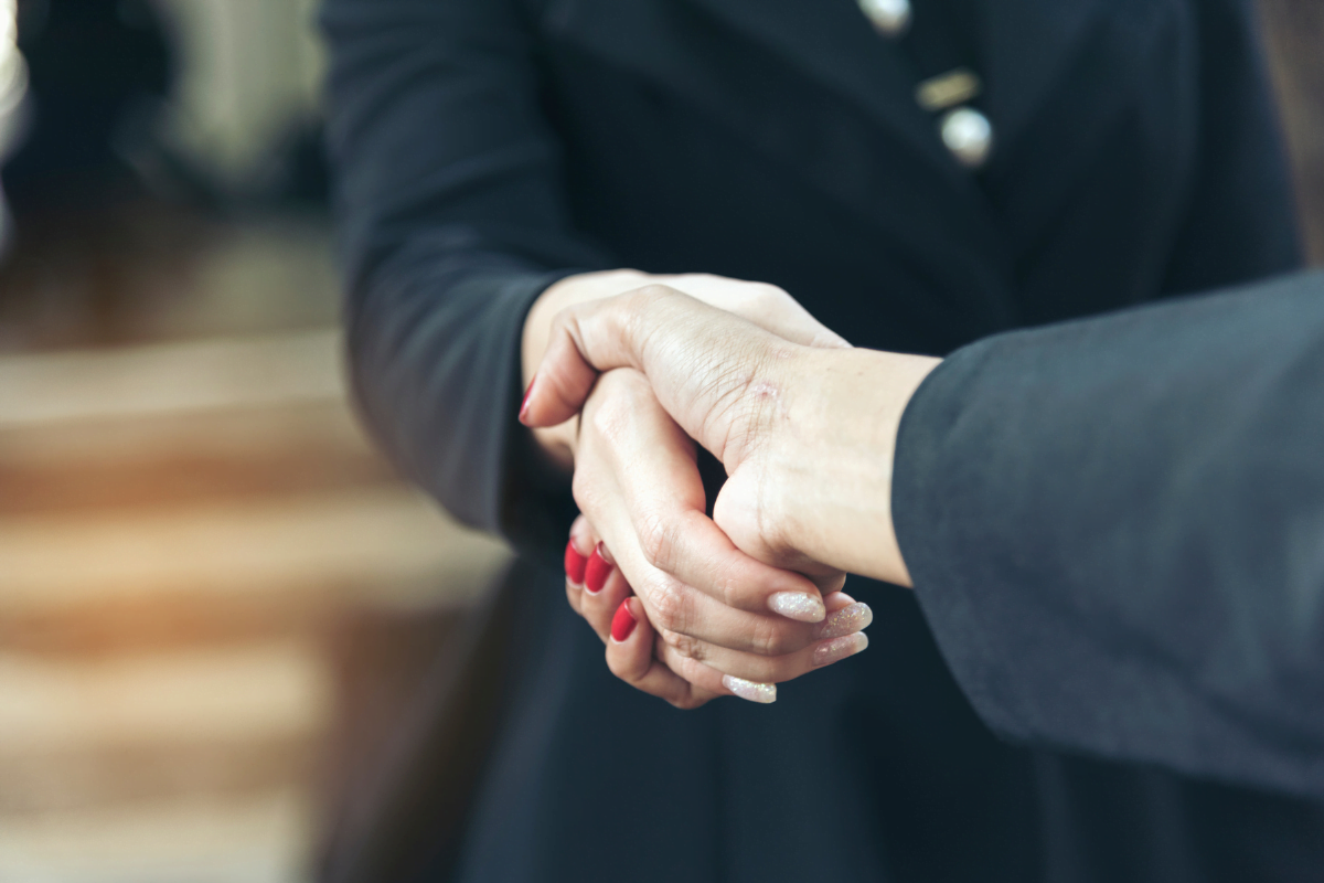 Two business people shaking hands, emphasizing customer loyalty.