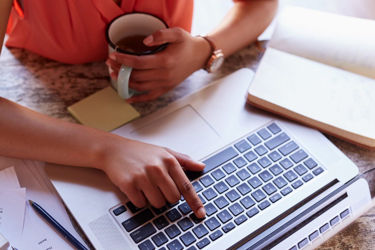 A businesswoman typing on her laptop and optimizing her Apple Business Connect profile.