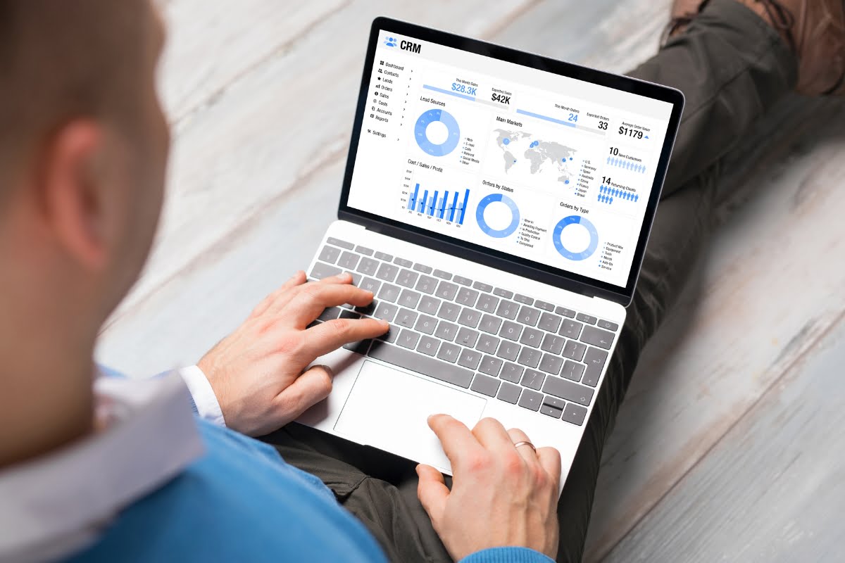 A man analyzing graphs on his laptop while managing automated marketing campaigns.