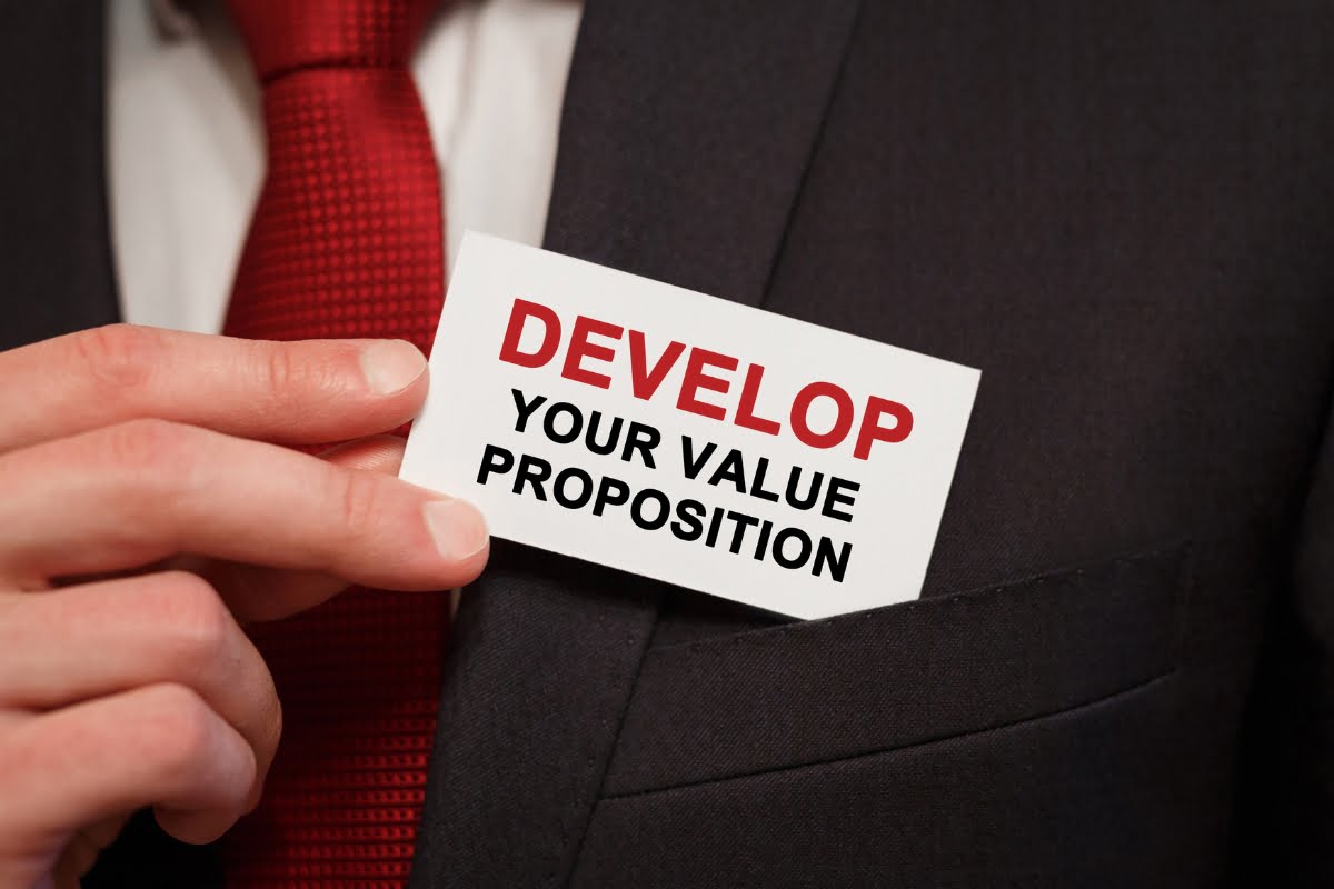 A man in a suit holding a card that says value proposition.