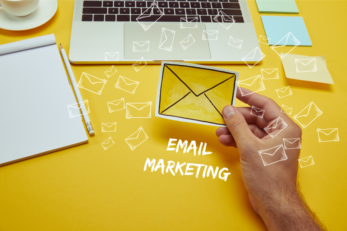 A hand holding an envelope with the word "email marketing."