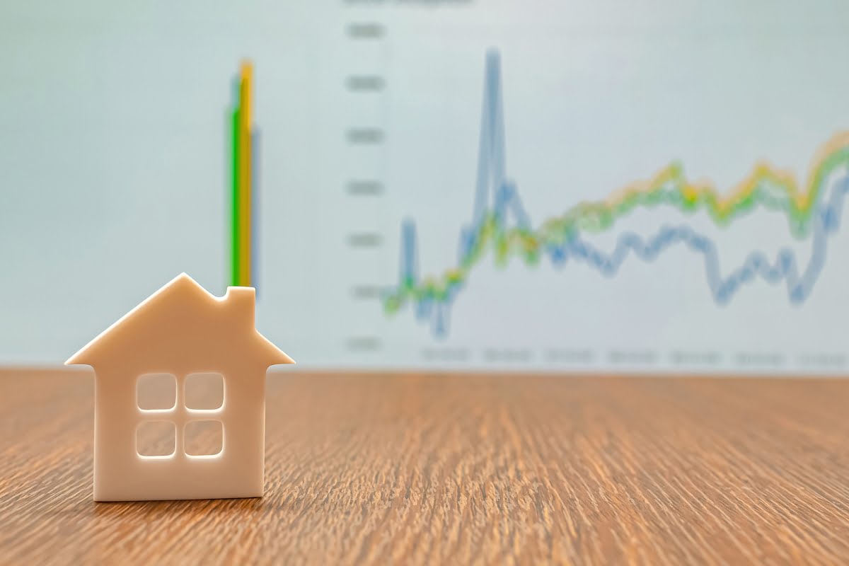 A graph-adorned house model on a table, showcasing a clever construction marketing strategy.