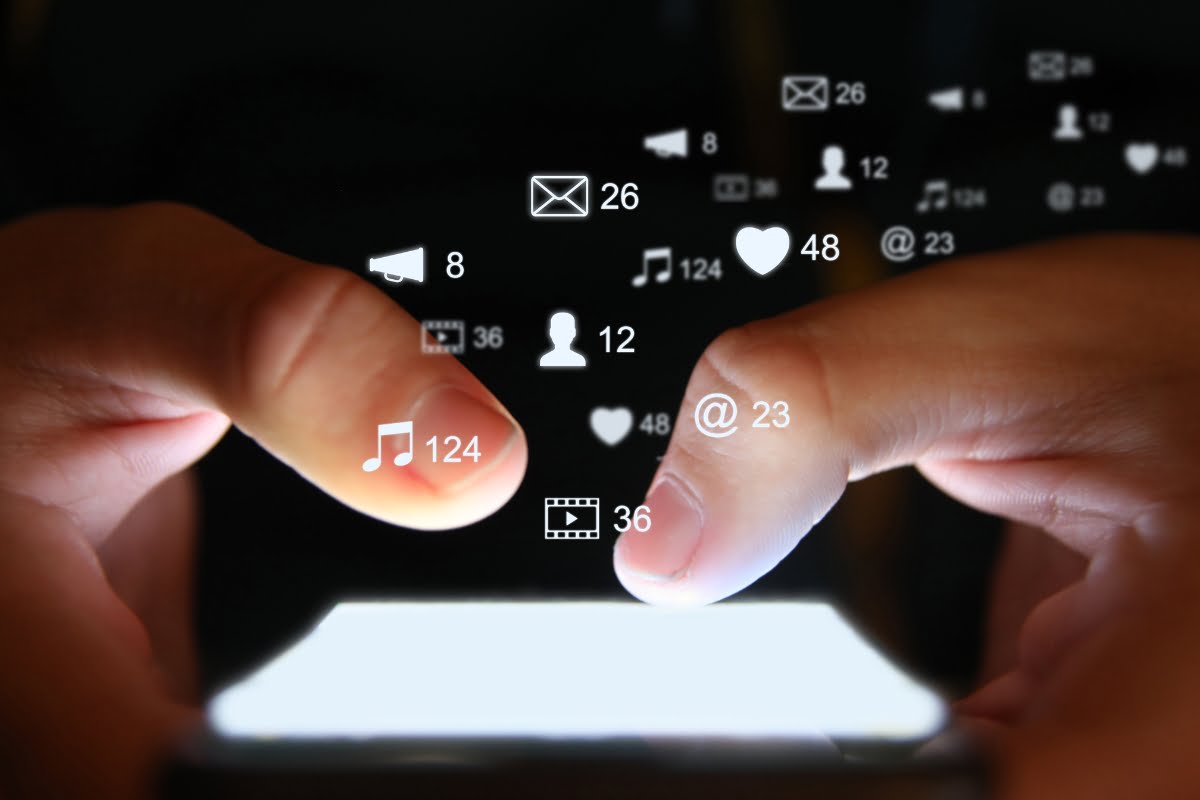 A person's hand is holding a cell phone, showcasing social icons as part of an innovative construction marketing strategy.