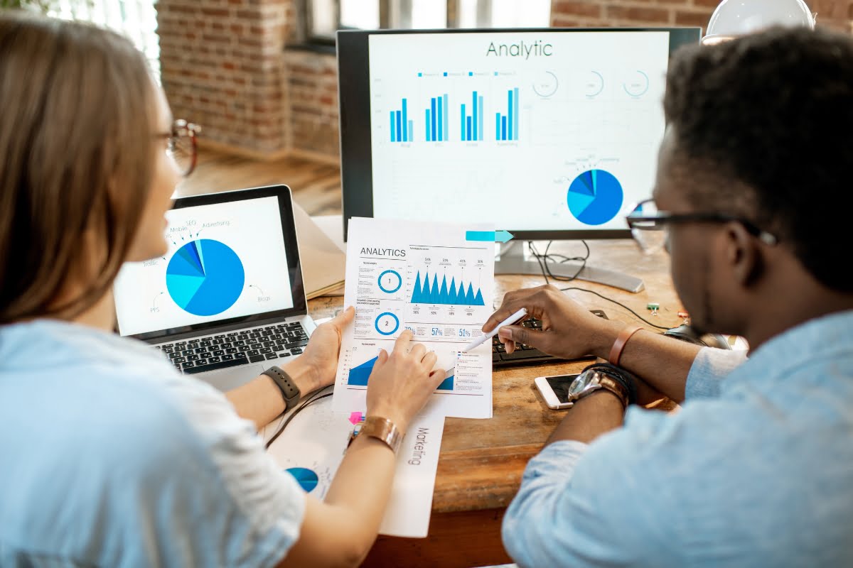 A group of people making data-driven decisions using graphs on a computer screen.