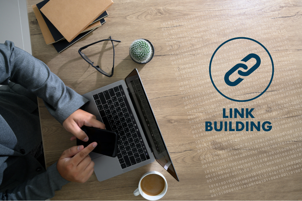 A man sitting at a desk with a laptop and a logo for link building, creating an SEO friendly website.