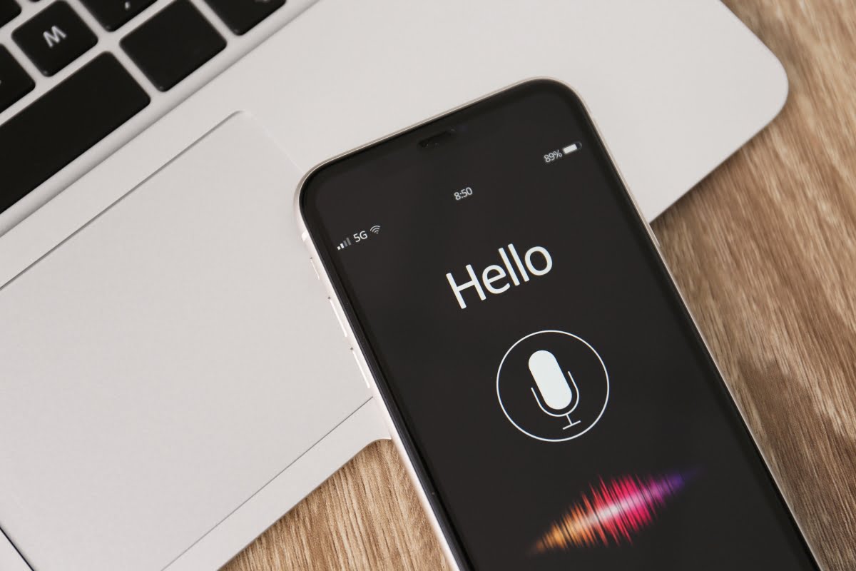 A phone displaying a hello sign, suggesting it supports voice search.