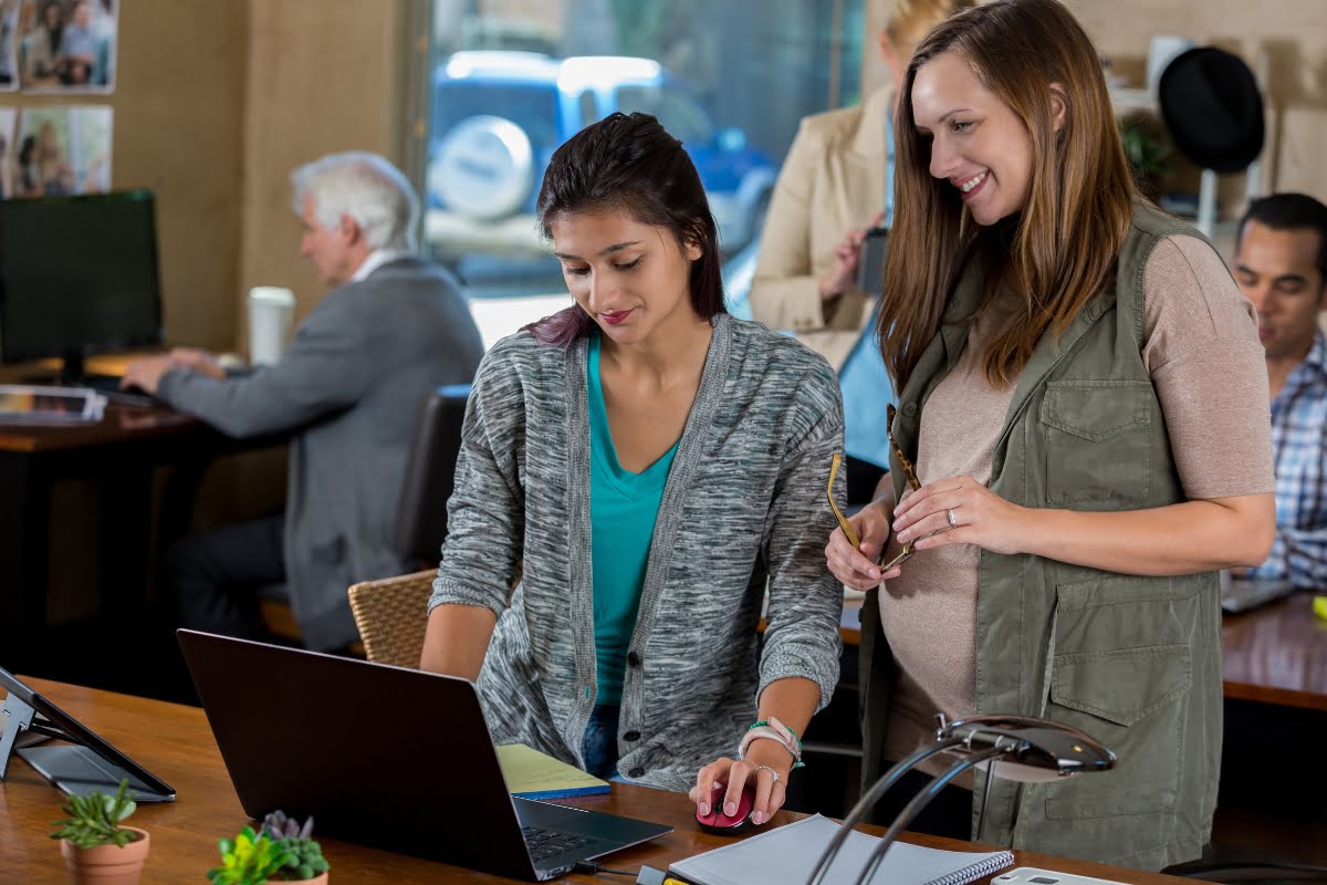 Two women fixing a suspended business profile on a laptop.