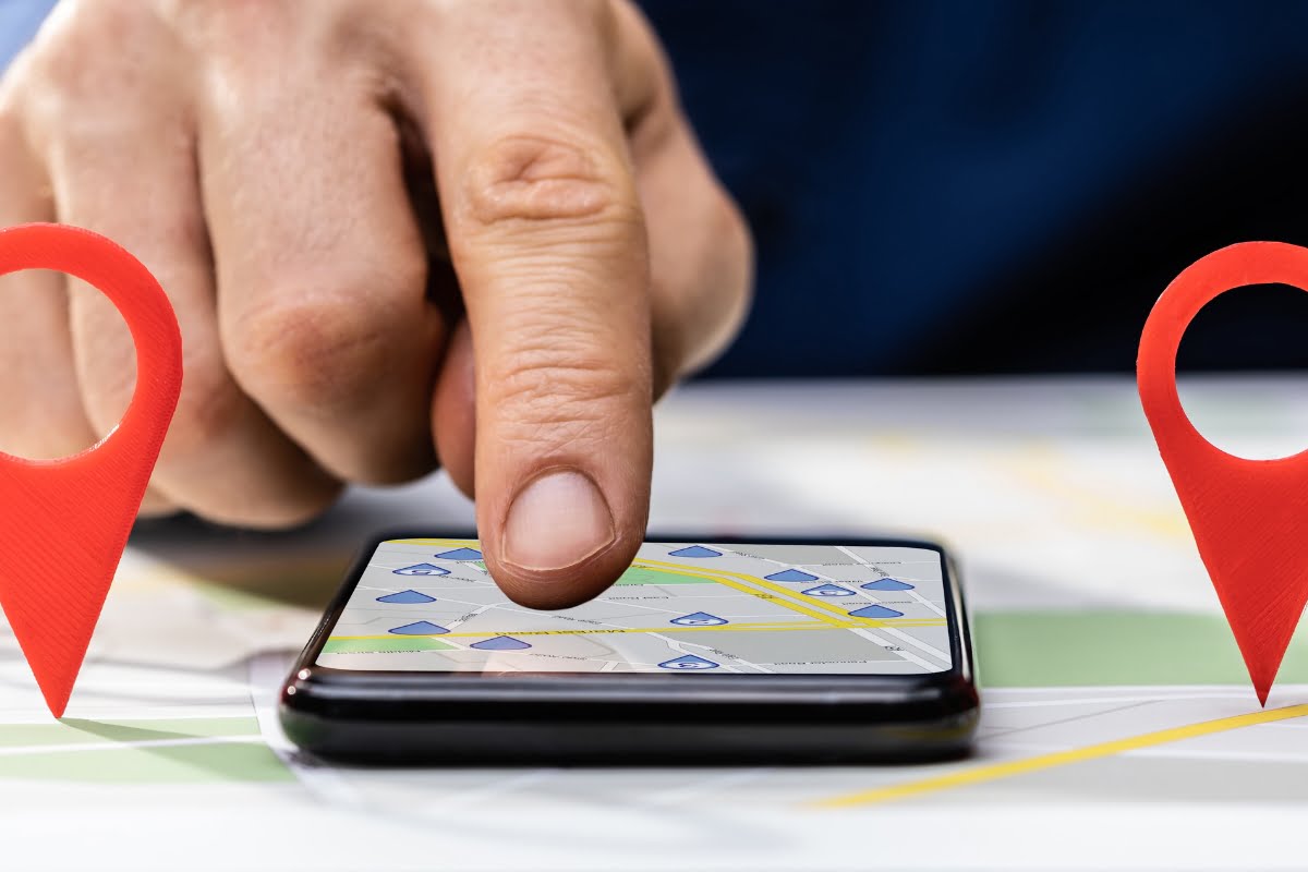 A man is using his phone to point at a map, demonstrating local store marketing techniques.