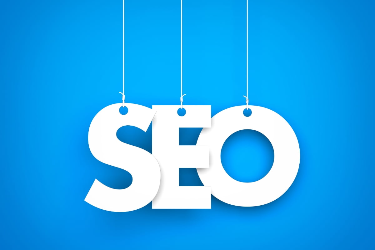 Search engine optimization techniques represented by the word "seo" hanging from strings on a blue background.