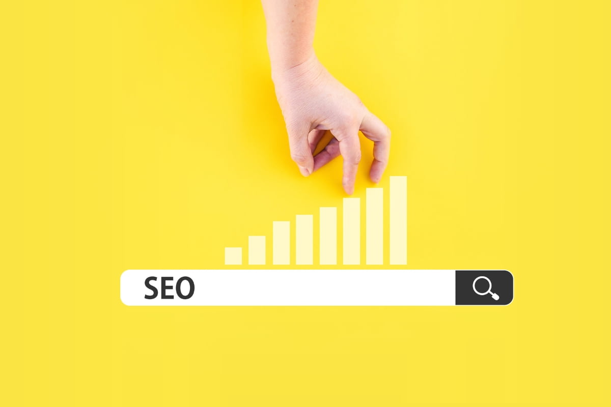 A hand is pointing at an SEO bar on a yellow background, demonstrating search engine optimization techniques.