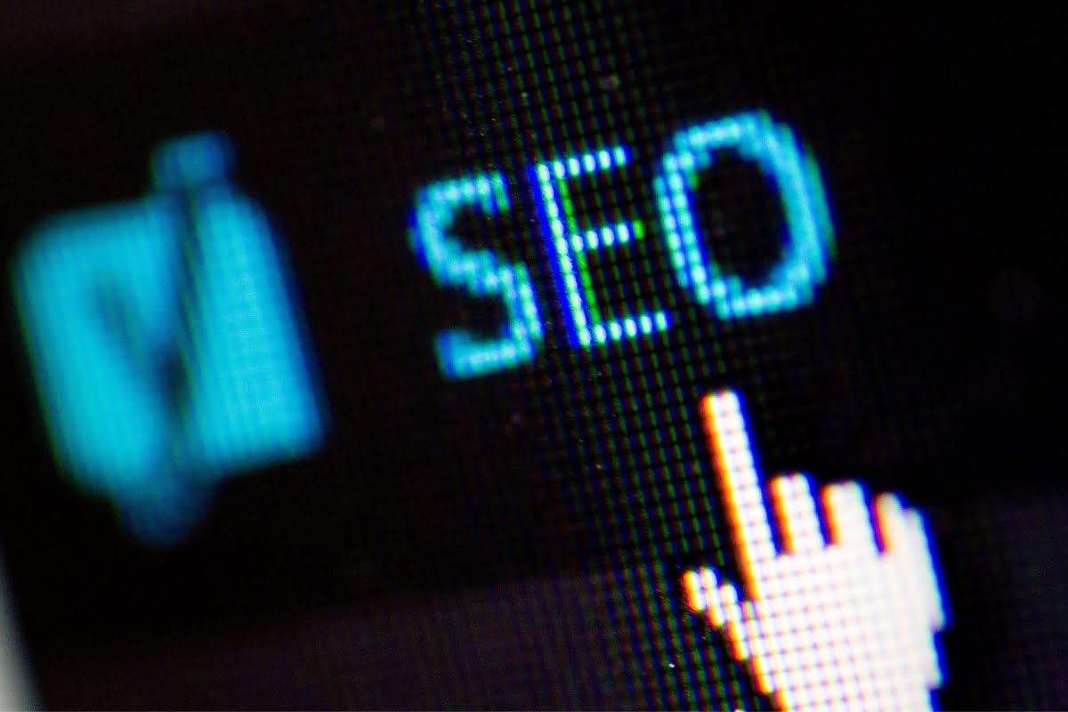 A hand is pointing at the SEO button on a computer screen, indicating its importance in adhering to the SEO checklist.