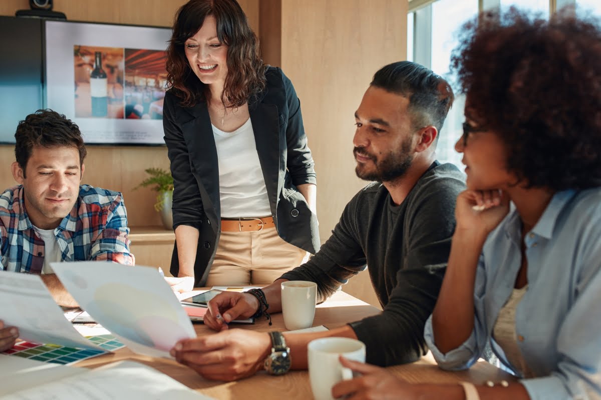 A boutique agency team sitting around a table in a meeting.