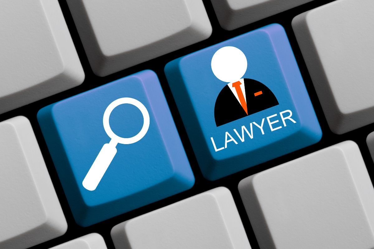 A lawyer utilizing digital marketing for law firms, represented by a magnifying glass and keyboard.