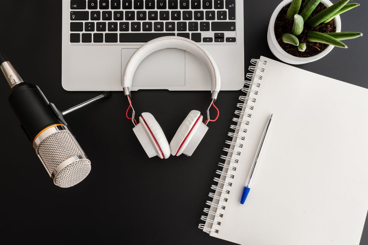 A laptop and headphones on a desk.