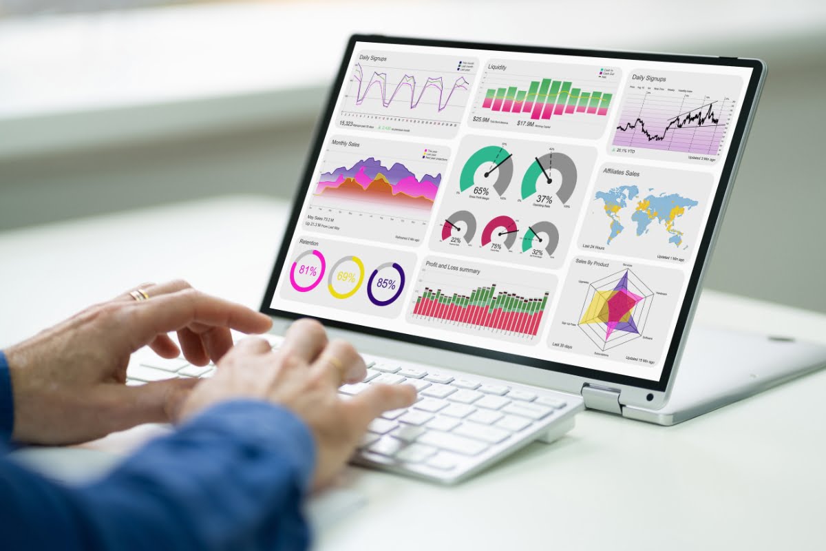 A person using a laptop to analyze graphs in order to achieve first page ranking on Google.