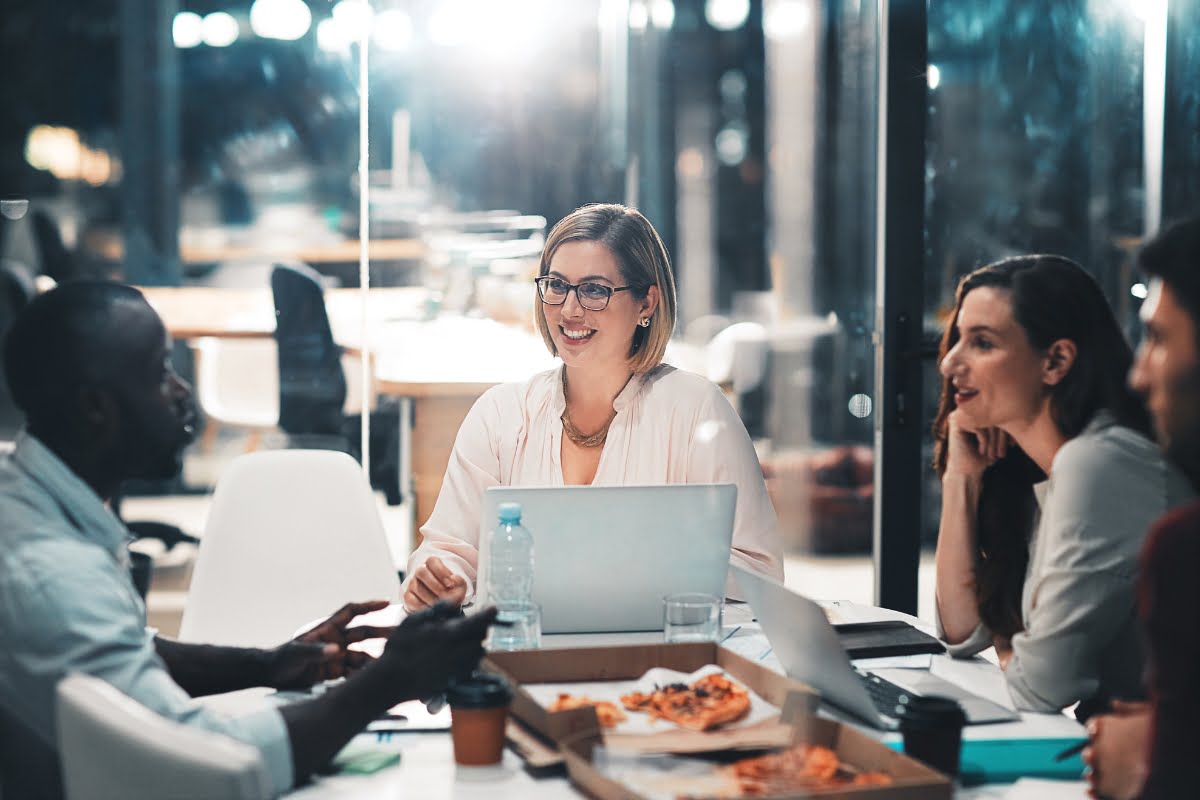 A group of people sitting around a table in a home improvement marketing agency office.