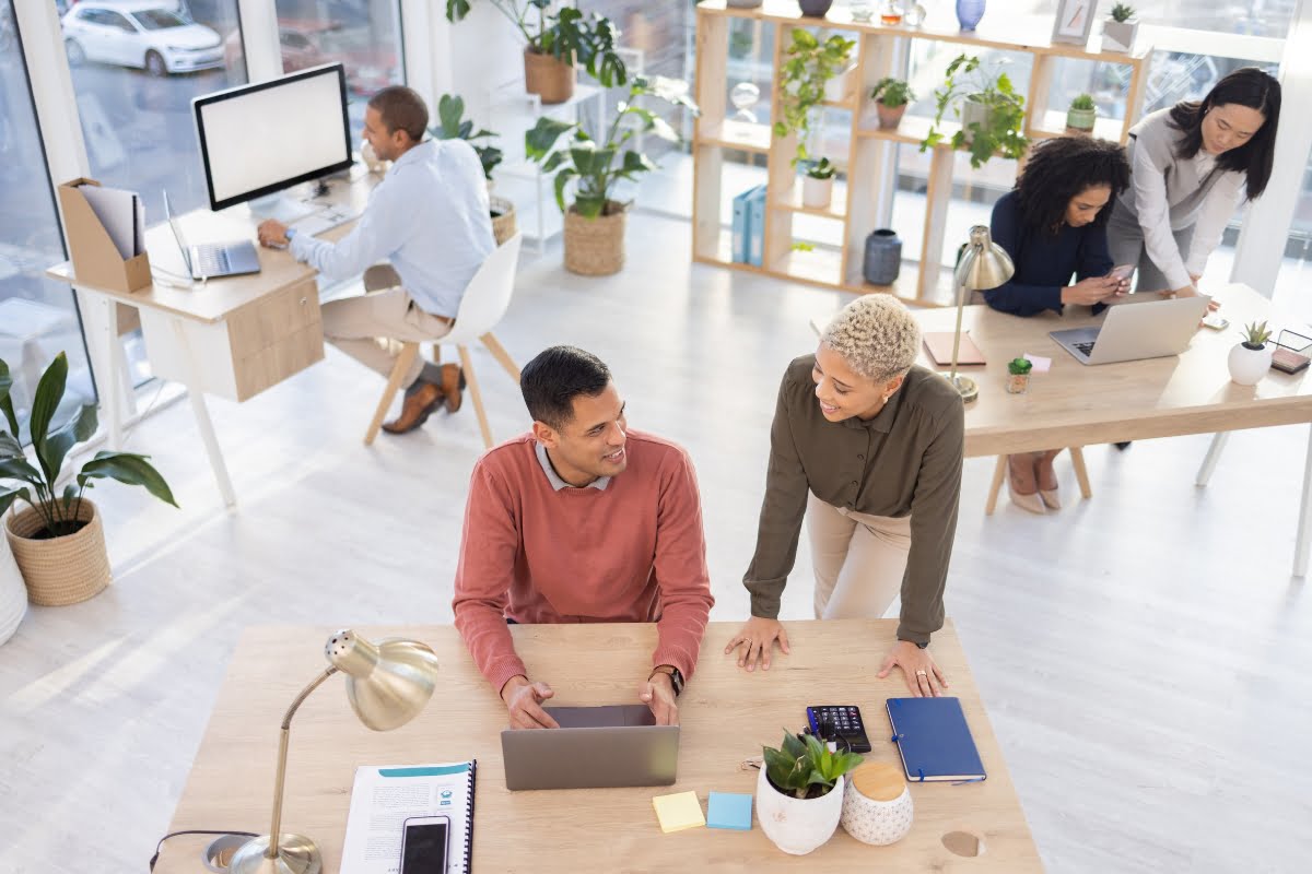 A group of people working at a desk in a home improvement marketing agency office.