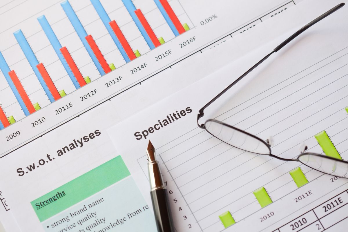 A sheet of paper with graphs, along with a pen and glasses, showing the steps to increase domain authority.