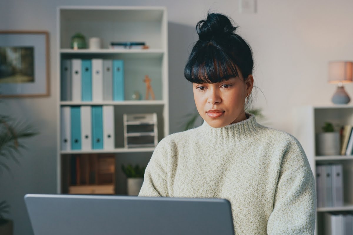 A woman updating WordPress on her laptop in her home office.