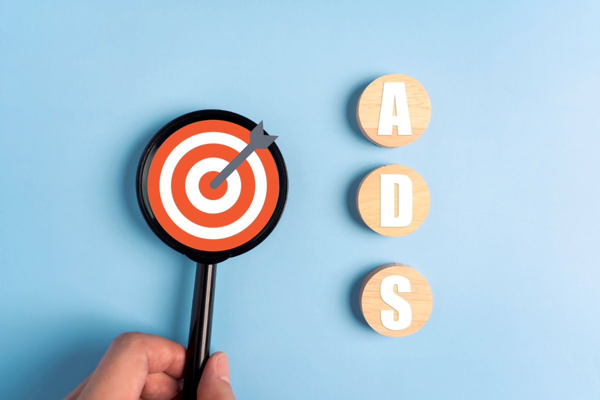 A person displaying a wooden target with the word "ad" on it for HVAC local service ads.