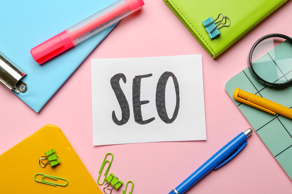 The word SEO is written on a pink background, showcasing effective keyword research tips.