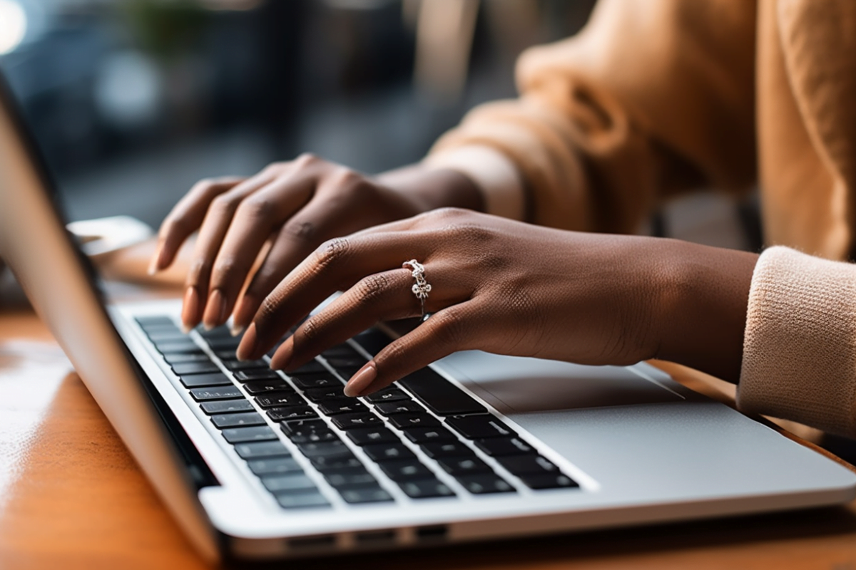 A woman's hands typing on a laptop for a landscape marketing content.