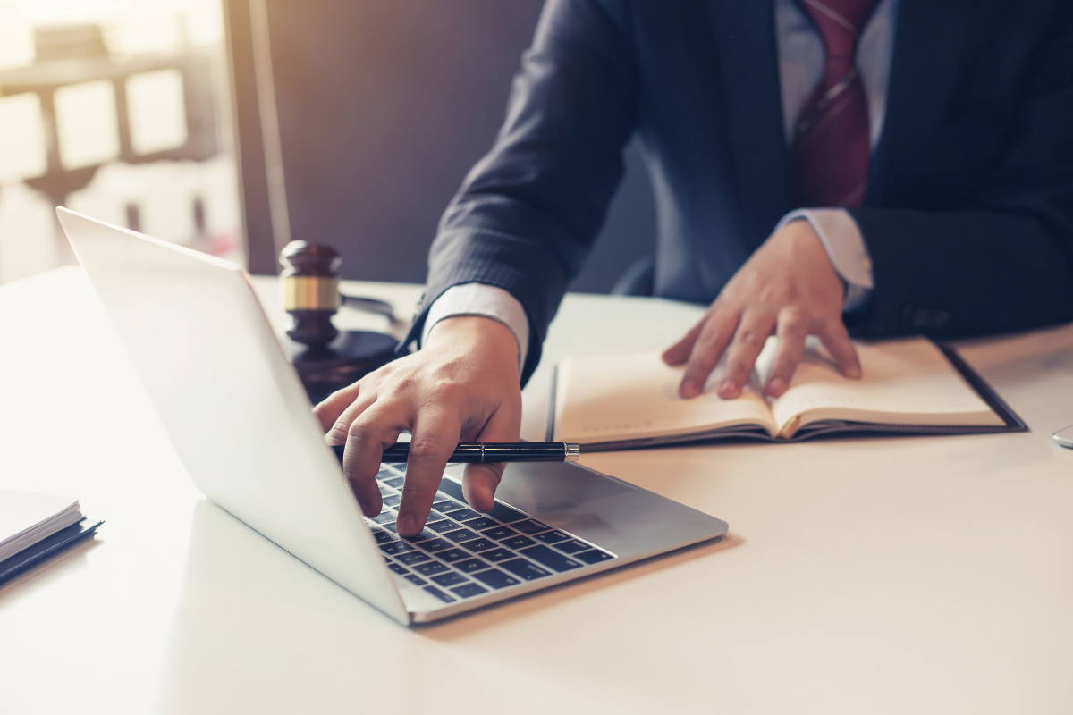 A legal professional in a suit, specializing in law firm website design, typing on a laptop.