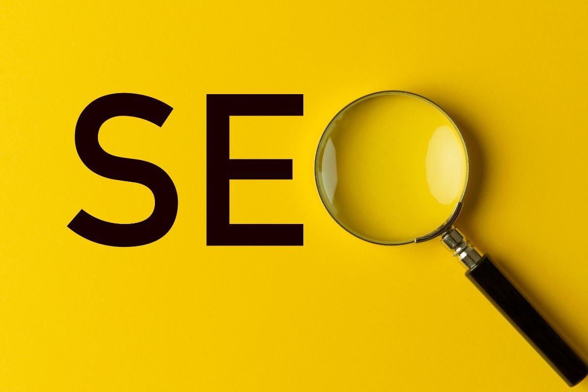 A magnifying glass over the word seo on a yellow background, focusing on marketing strategies for startups.