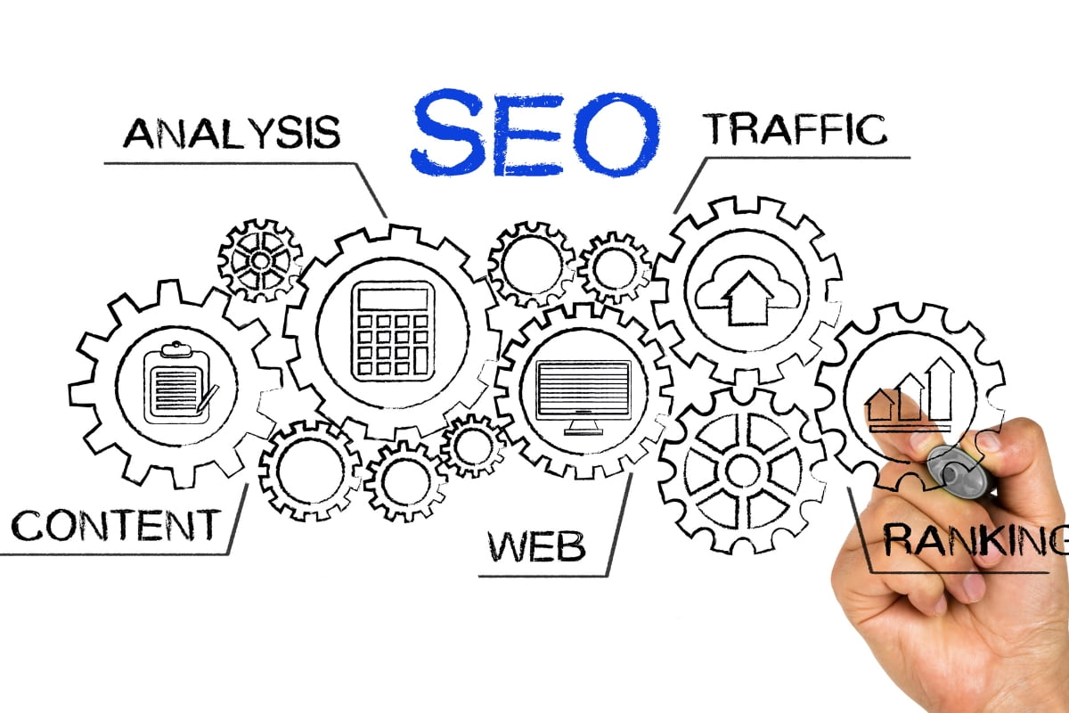 A hand drawing the word "seo" on a piece of paper, showcasing a redesigning a website concept.