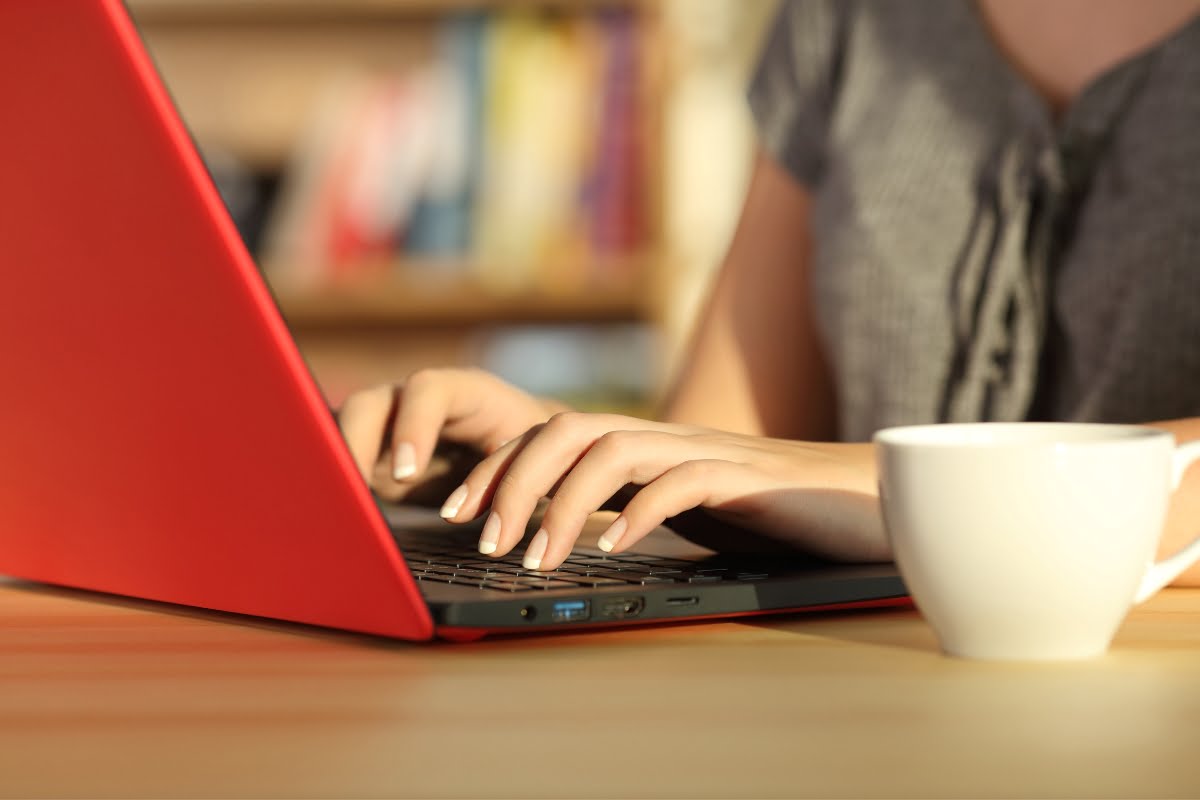 SEO Title: The woman working on her red laptop while typing