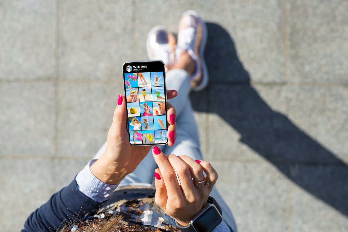 A woman utilizing spa marketing techniques while holding a smartphone with pictures on it.