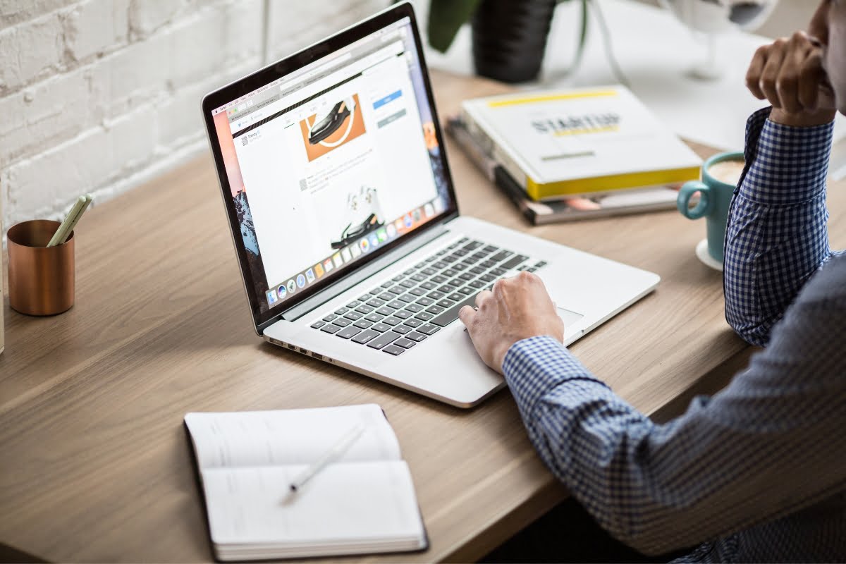 A man working on a laptop at a desk to boost spa marketing efforts.