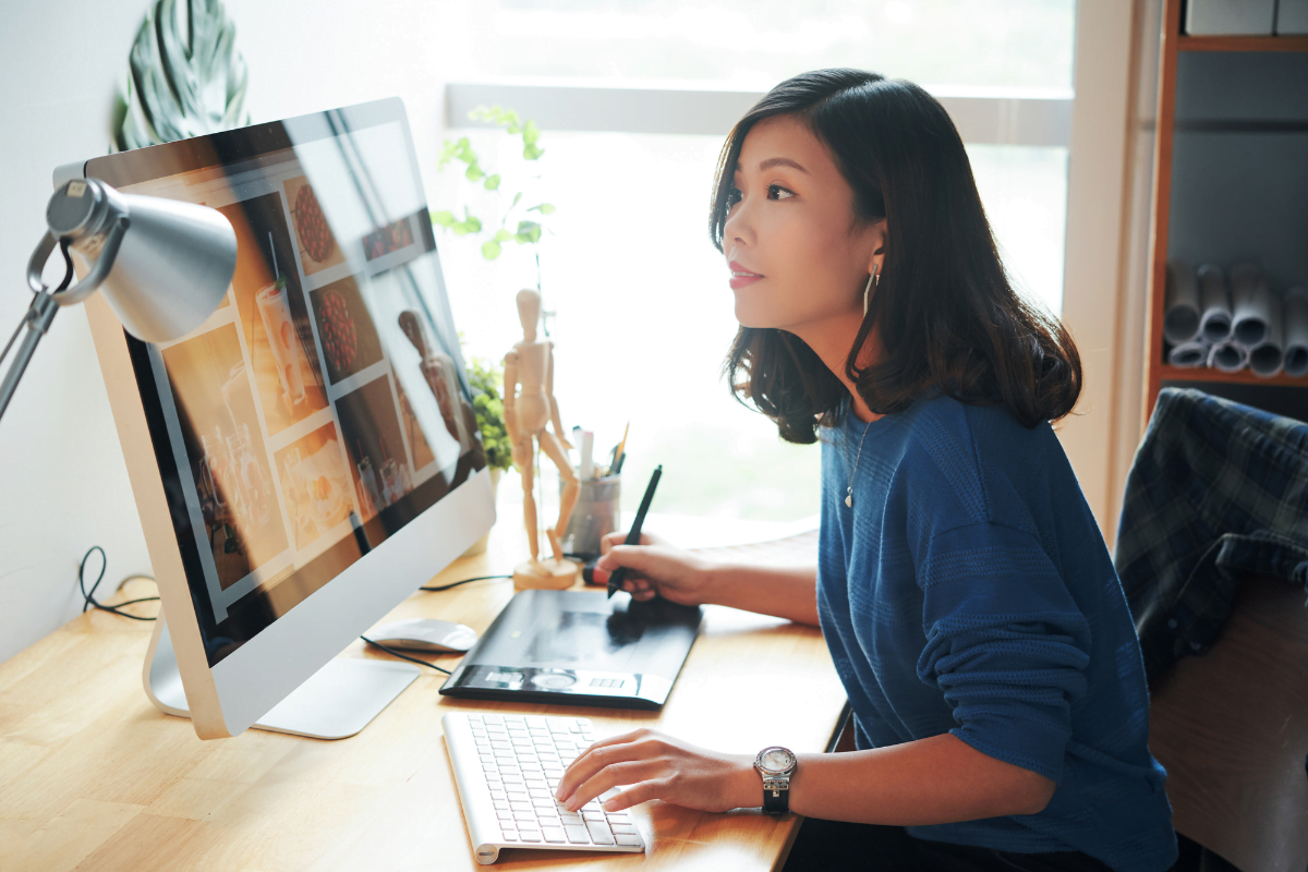 A woman is working on a computer at home as a WordPress web designer.