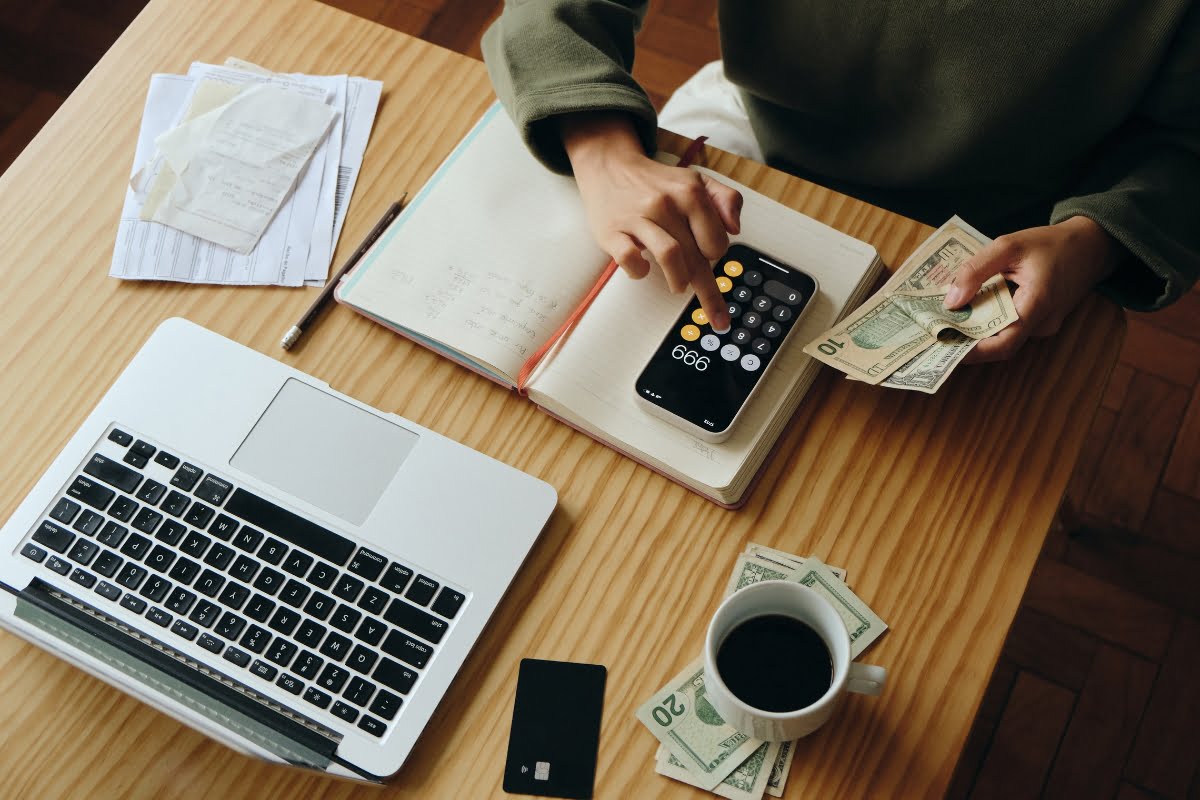 A woman is sitting at a desk with a laptop, utilizing advanced AI algorithms to optimize personalization and manage financial transactions.