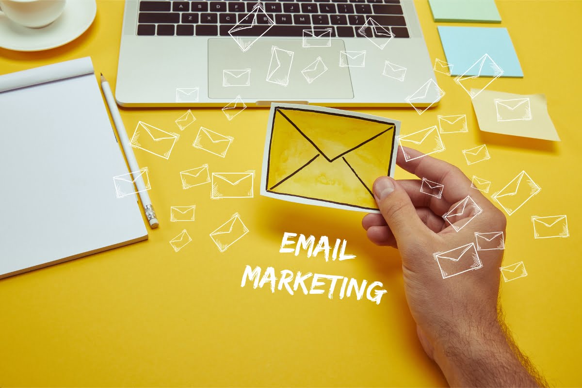 A hand holding an envelope with the word email marketing on it, enhanced with AI-powered personalization.