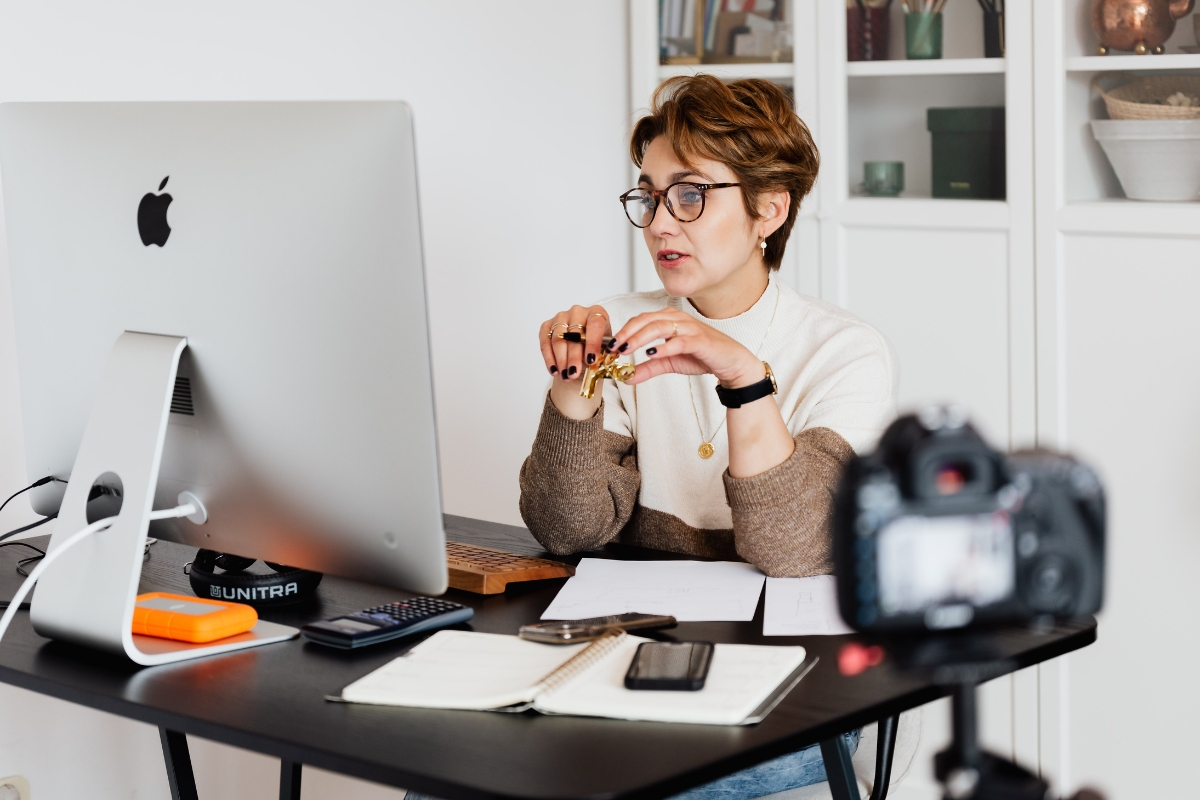 A woman sitting at a desk, engrossed in her computer as she searches for the best hosting for SEO.