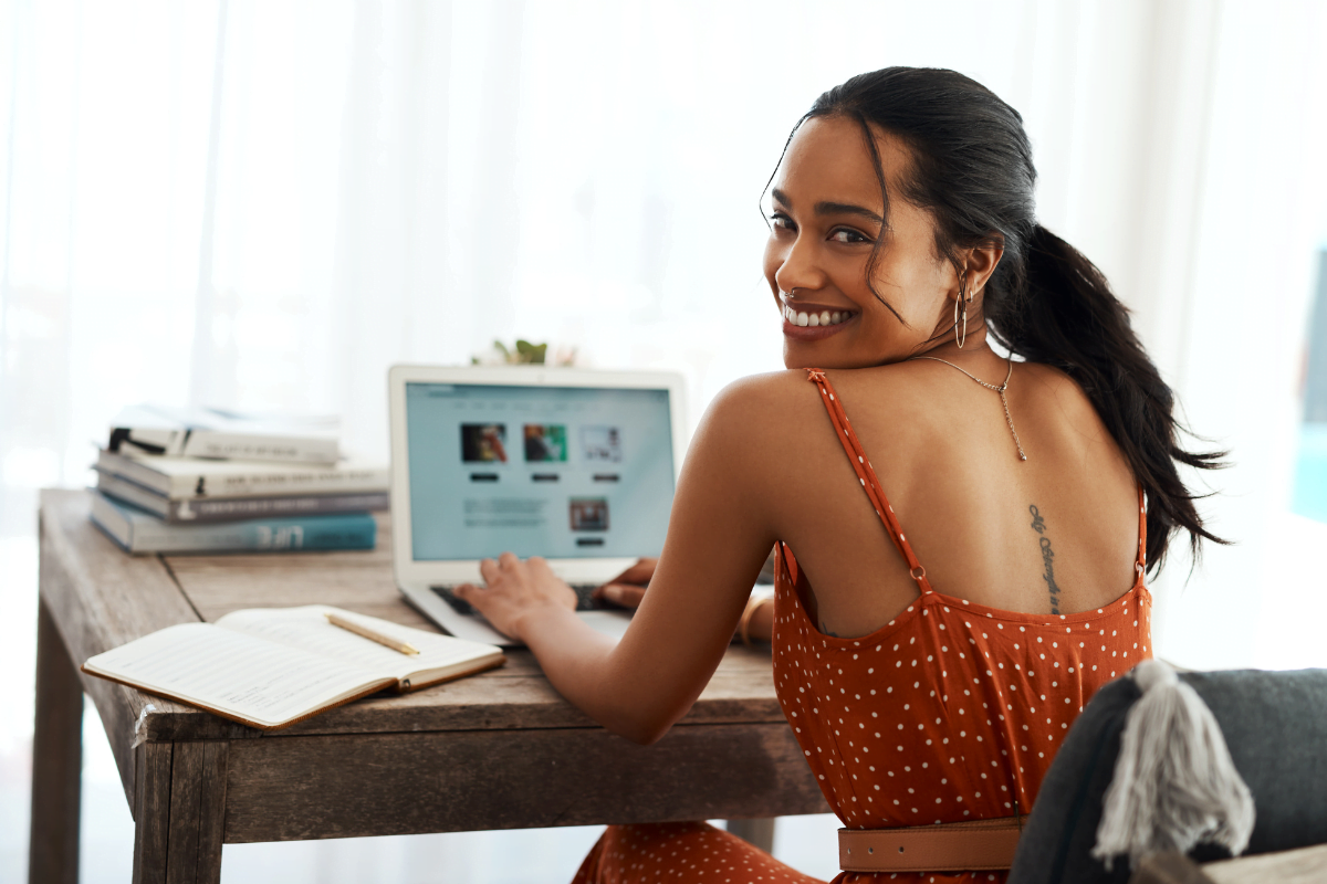 A woman sitting at a desk, passionately blogging for small businesses with her laptop.