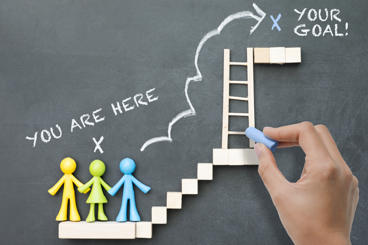 Human figures trying to climb up a ladder, symbolizing how to reach your goals.