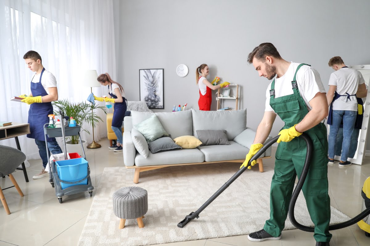 A group of people cleaning a living room for a carpet cleaning ads.