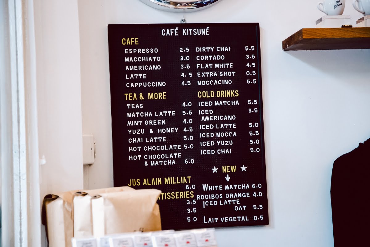 A coffee shop catering to clients with a menu on the wall.