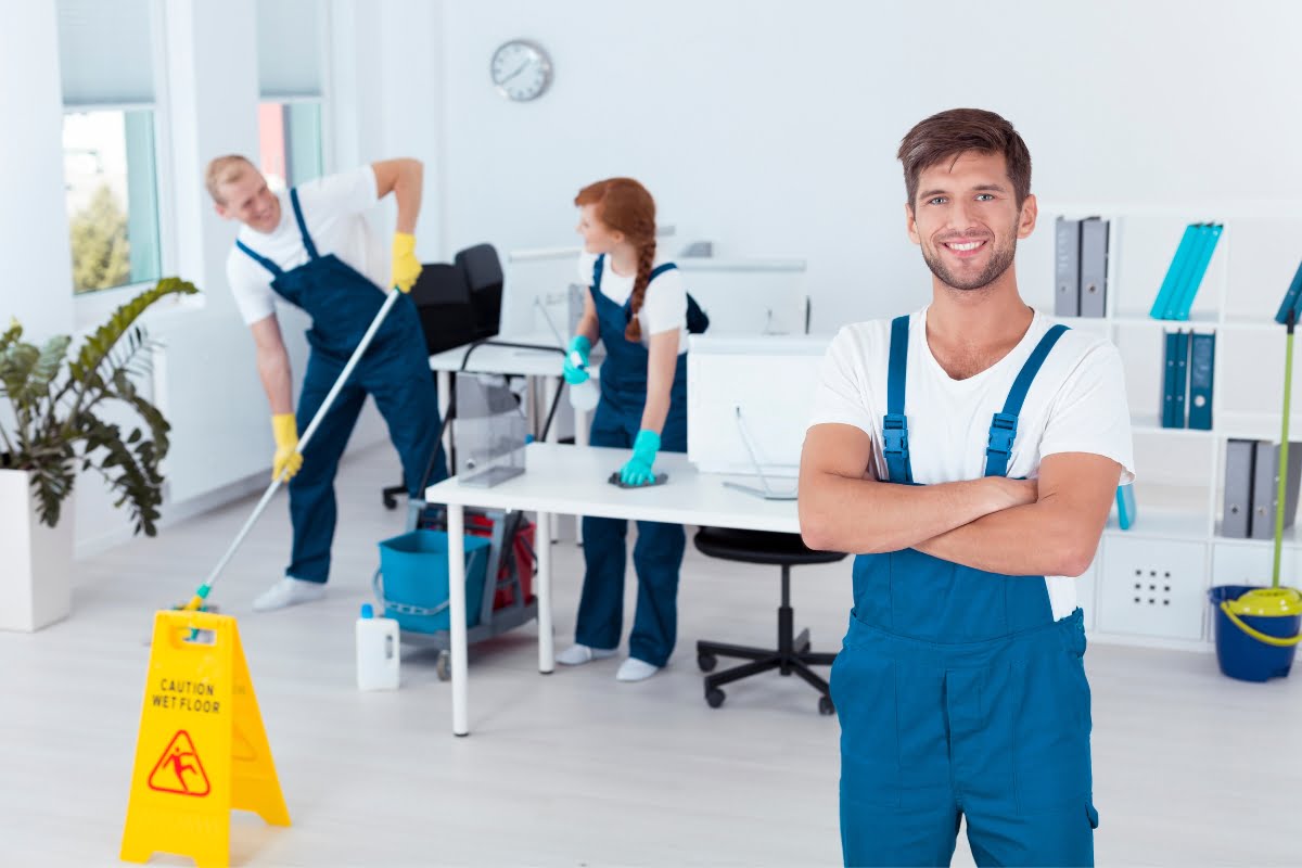 A group of people standing in an office, showcasing cleaning advertising ideas with a mop.