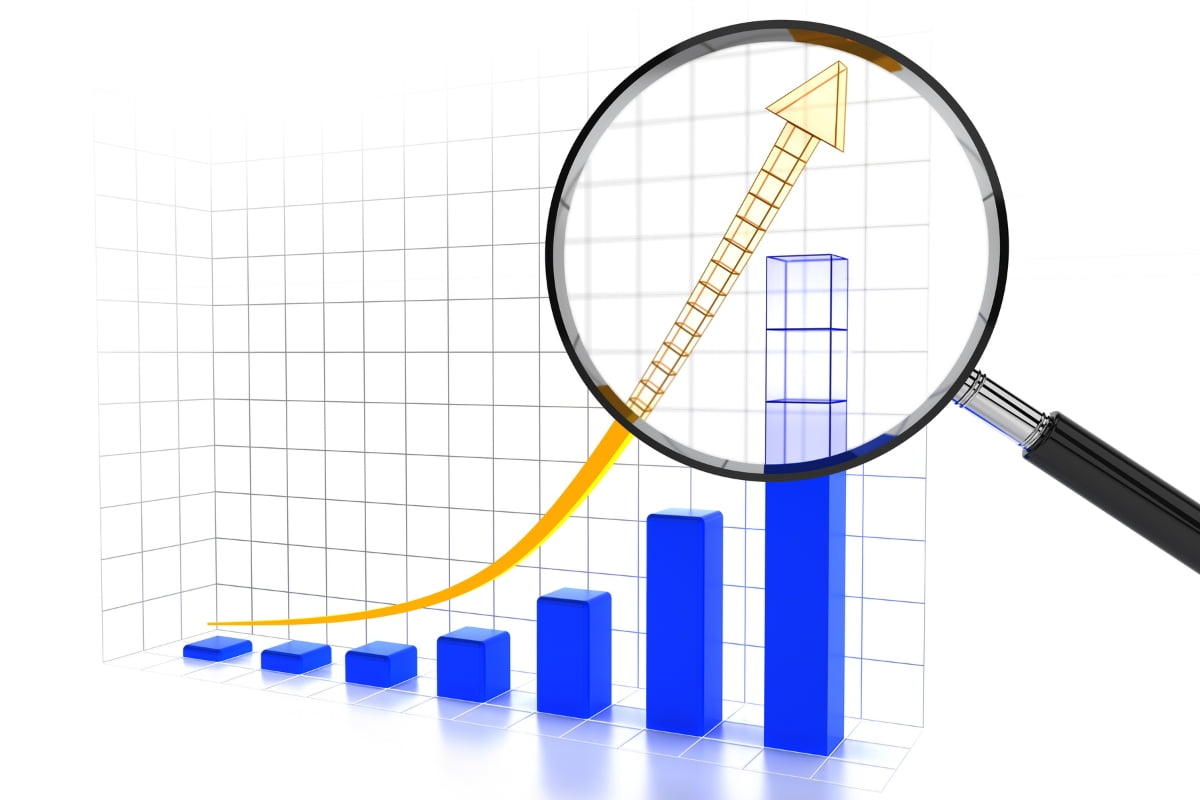 A chart with an upward arrow is examined using a magnifying glass, reflecting the use of Google Trends.