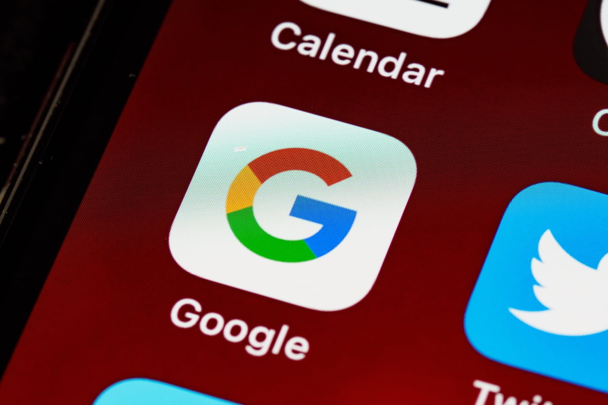 The Google logo is prominently displayed on a smartphone, symbolizing the impact of Google Trends.