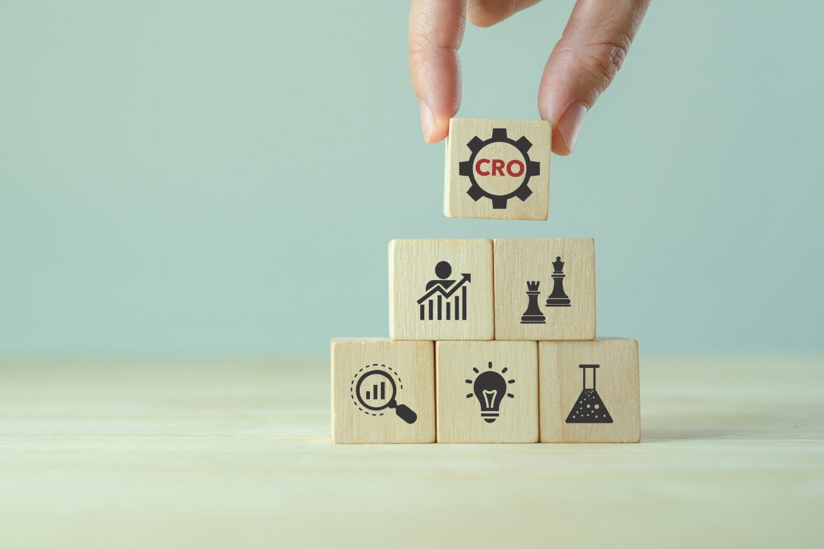 A hand holding wooden blocks with the word cdo on them, demonstrating how to convert traffic into sales.